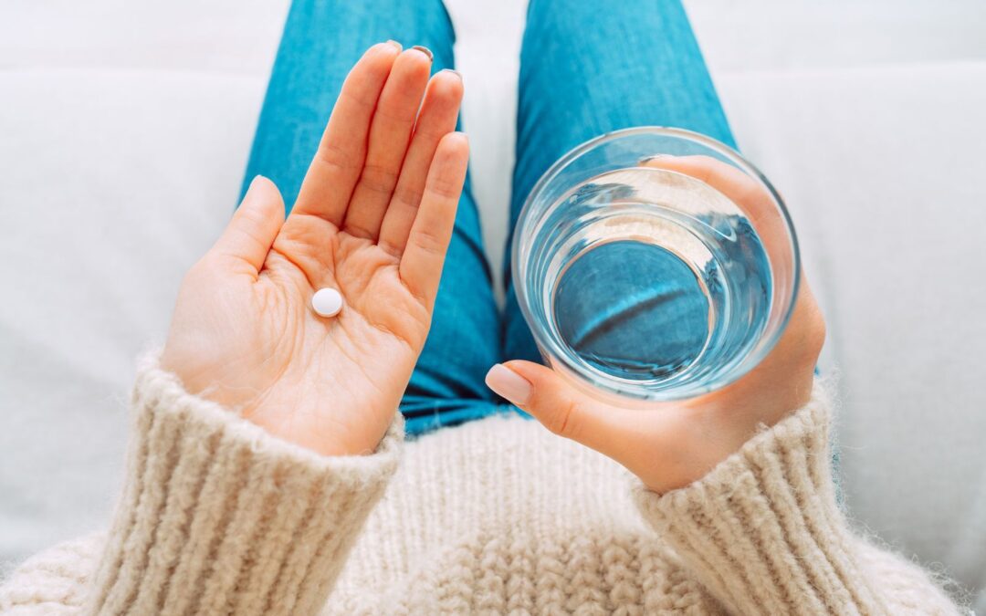 Woman with glass of water taking abortion pill